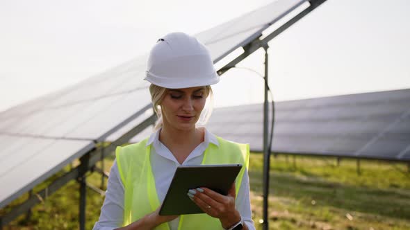 Inspector Engineer Woman Holding Digital Tablet Working in Solar Panels Power Farm Photovoltaic Cell