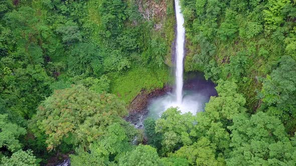 Aerial Pull Back of La Fortuna Waterfall and turquoise pool in Costa Rica jungle alt