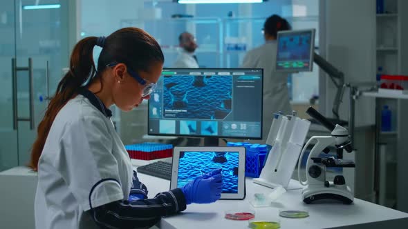 Lab Technician Doctor Analyzing Virus Evolution Looking on Digital Tablet alt
