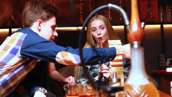 Young People Have Fun Playing Board Games at a Table in Cafe alt