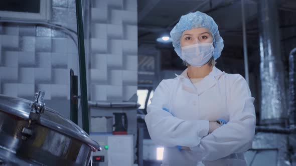 Female Worker in Medical Mask Stands Near Machine Tool