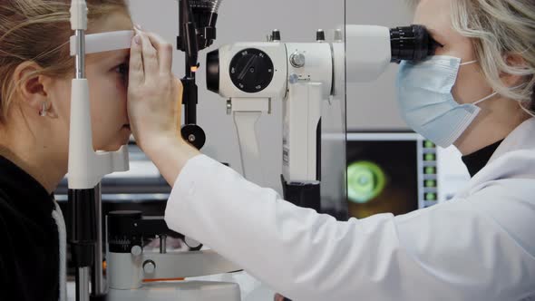 The Ophthalmologist Examines the Patient's Eye and Then Looks Into the Camera alt