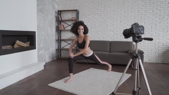 Online Yoga Coach. Young Smiling African Lady Vlogging and Leading the Youga Classes. alt