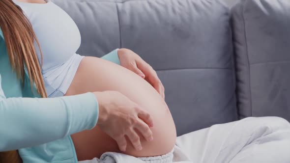 Young pregnant woman is resting at home and expecting a baby. alt