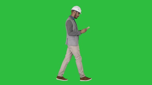 Young architect reading textbook or notebook while walking alt