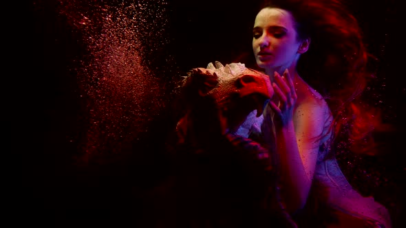Enchanted Young Lady is Floating with Dragon in Dark Deepness of Oceanic Water Slow Motion Shot alt