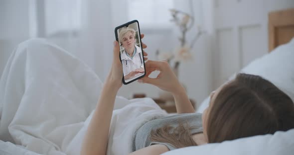 Woman at Home Using Smartphone To Talk To Her Doctor Via Video Conference Medical App. Beautiful alt
