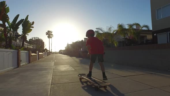 A boy skateboarding in a neighborhood. alt