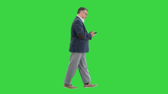 Senior Businessman Walking and Making a Call on a Green Screen Chroma Key alt