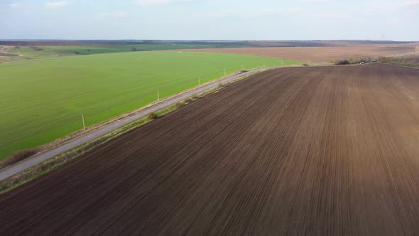 Flying above green and cultivated spring fields