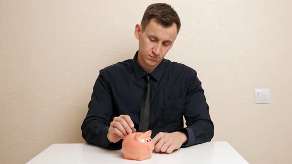 Man Hand Holds Bronze Coins and Throws Into Piggy Bank Slot alt