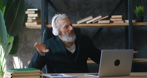 Joyful Mature Business Man Dancing in Workplace Wearing Wireless Headphones Listening Music While alt