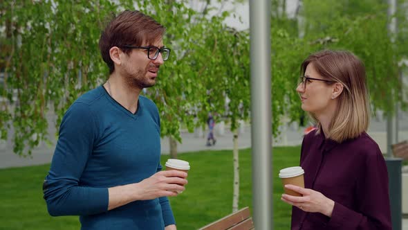 Two colleagues employees discussing planning during break out of office. alt