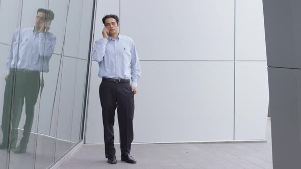 Young businessman talking on cell phone outdoors