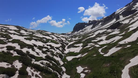 Mountain Partly Covered with Snow with Green Valley on Clear Sunny Day alt