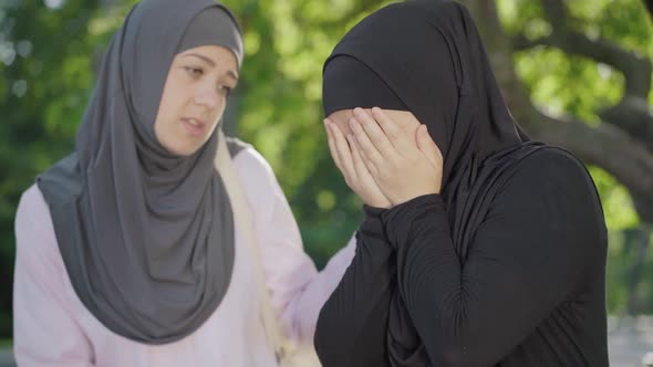 Desperate Muslim Woman in Hijab Crying As Friend Calming Her Down. Portrait of Young University alt