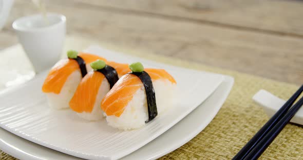 Sushi in tray with tea in cup alt
