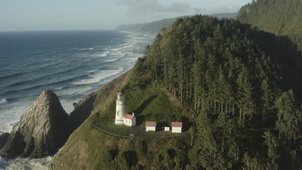 Wide circumnavigating aerial revealing Haceta Head lighthouse in Oregon alt