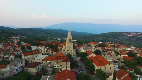 Moving aerial drone point of view of St. Nicholas Church in Selca Croatia Europe alt