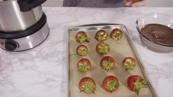 Flat lay. Step by step. Dipping organic strawberries into melted milk chocolate. alt