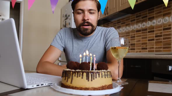Man Blowing Out the Candle on the Birthday Cake and Making Video Call alt