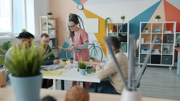 Multiracial Team of Young People Application Developers Choosing Colors Talking in Workplace alt