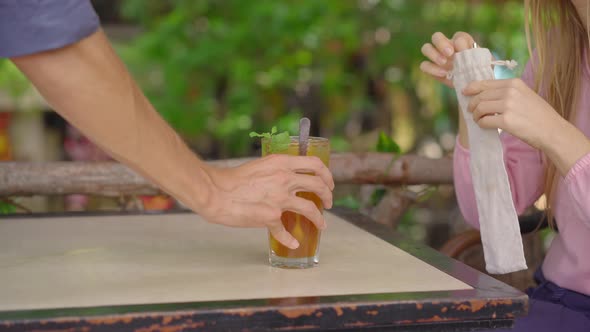 Closeup Shot. In a Cafe, a Young Woman Uses Her Own Reusable Metallic Straws Instead of a Single-use alt