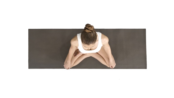 Young sporty woman practicing yoga sitting in lotus pose alt