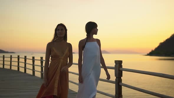 Warm Sunset in the Exotic Resort Two Girls in Dresses Walking Along the Esplanade Enjoying Their alt