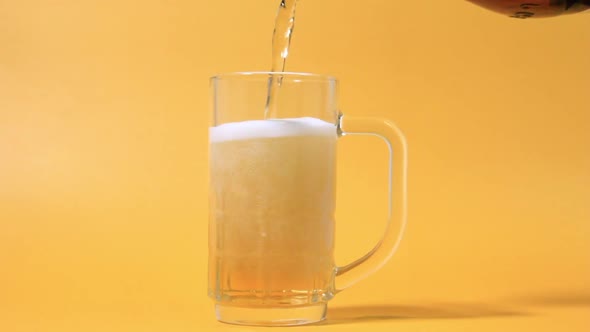 Purring Fresh Beer In The Glass From The Top Of Bottle In Close Up Angle View