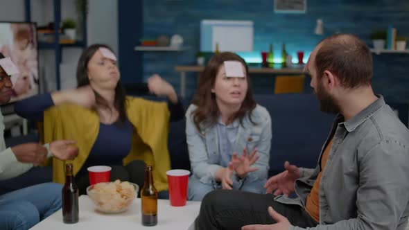 Mixed Race Friends Socializing During Creative Party While Playing Funny Guess Who Game alt