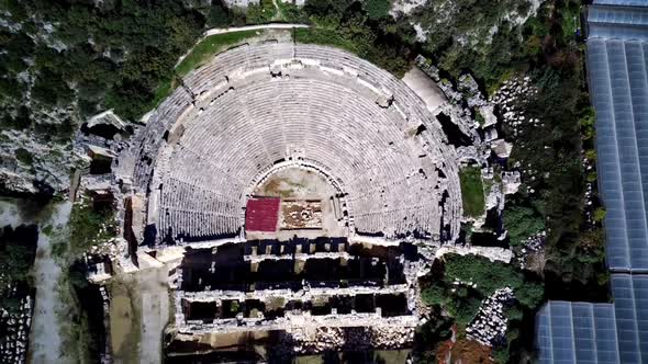 High angle drone aerial view of ancient greek rock cut lykian empire amphitheatre and tombs in Myra alt