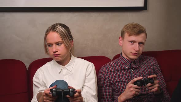 Young People Playing Video Games on Console and Boring Yawning While Sitting on Couch in Front of Tv