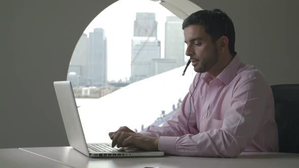 MS DS Businessman talking on phone while using laptop in office