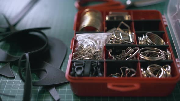 Professional Tailor Hand Takes Accessory From Red Box alt