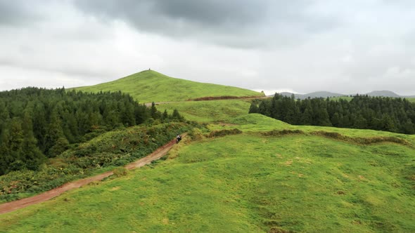 Couple on Motorcycle Riding on Road in Mountains Sao Miguel Island Azores alt