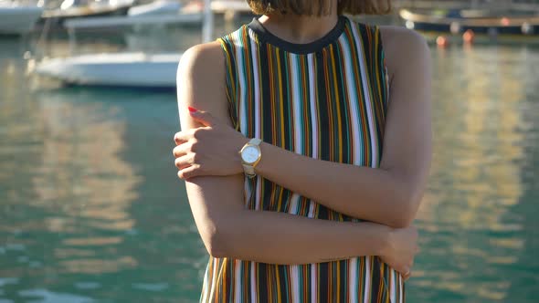 A woman with watch, hat, sunglasses, striped dress traveling, Portofino, Italy, luxury resort Europe alt