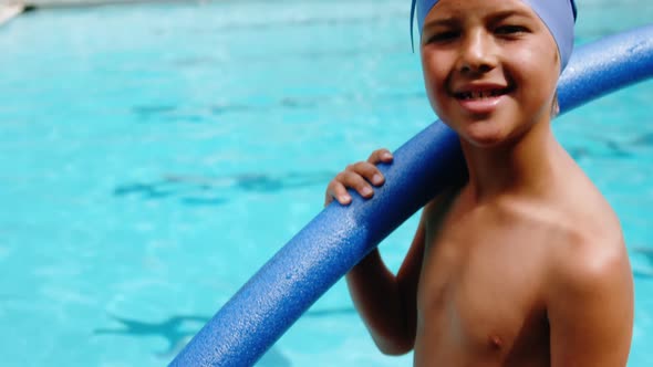 Portrait of young boy holding inflatable tube alt