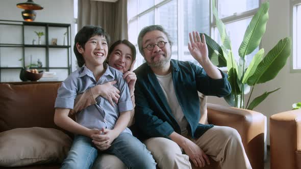 happiness sweet asian family father mother and son sitting together on sofa video calling