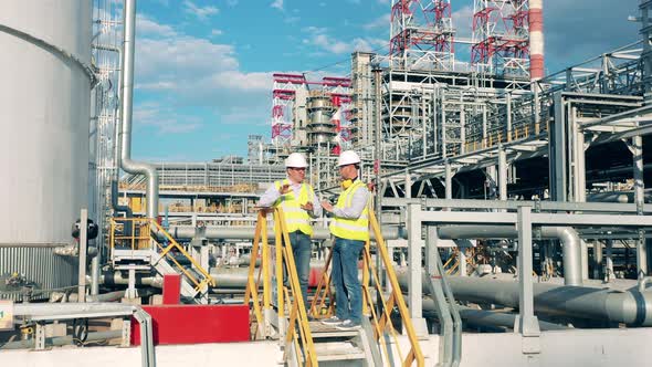 Workers are Planning a Project on the Premises of the Oil Refinery alt
