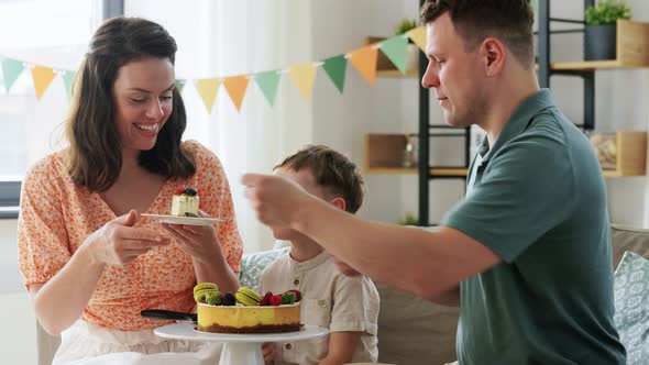 Happy Family Eating Birthday Cake at Home Party alt