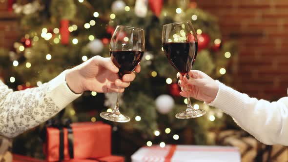 Hands of Unknown People Who Cheering With Glasses of Wine Against Christmas Tree Decorated