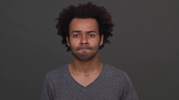 Darkskinned Man with Afro Haircut Standing with Apologetic Glance and Nodding Negatively Isolated alt