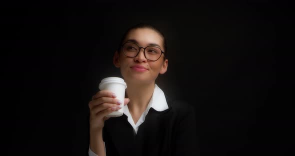Brunette in Glasses and Office Clothes Drinks Coffee From a White Paper Cup alt