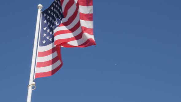 United States flag in front of blue sky slow waving on wind 4K 2160p UltraHD footage - American flag