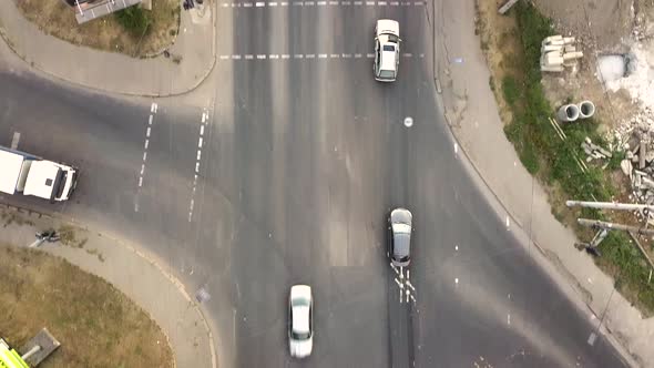 Top down aerial view of city traffic with cars moving on a street at roads intersection. alt