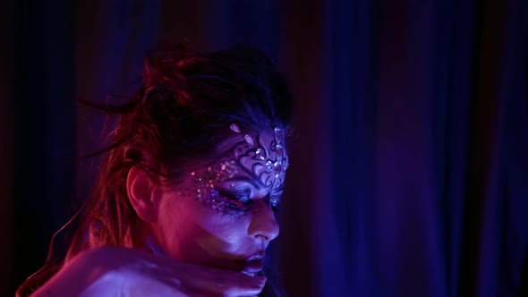 Excited Eccentric Woman with Art Makeup Is Moving in Darkness Passionately alt