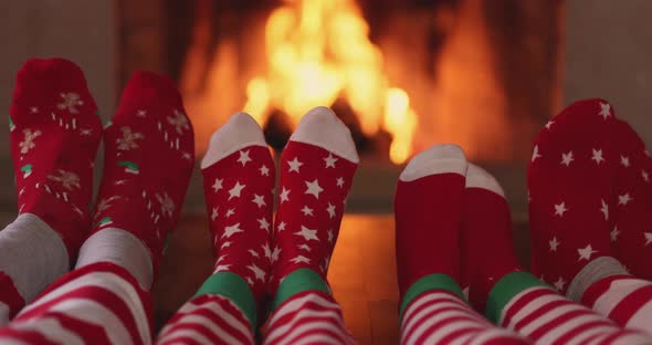 Family in Christmas socks near fireplace