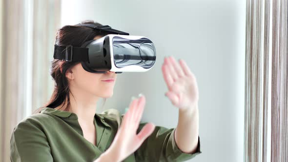 Amazed Concentrated Young Woman in Vr Helmet Gesticulating Having Good Time at Home alt