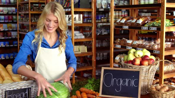 Smiling staff holding bread in organic section alt